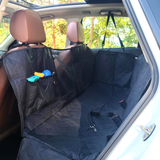 Normal dog backseat cover installed in the backseat of a car with items in the pockets and a visible seatbelt opening